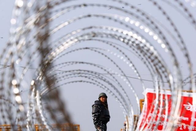 police officer in riot gear stands guard behind concertina wire at a protest against farm laws at the delhi uttar pradesh border in ghaziabad india february 3 2021 photo reuters