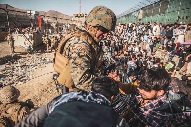 A US Marine assists at an Evacuation Control Check Point (ECC) during an evacuation at Hamid Karzai International Airport, Kabul, Afghanistan, August 26, 2021. PHOTO: REUTERS