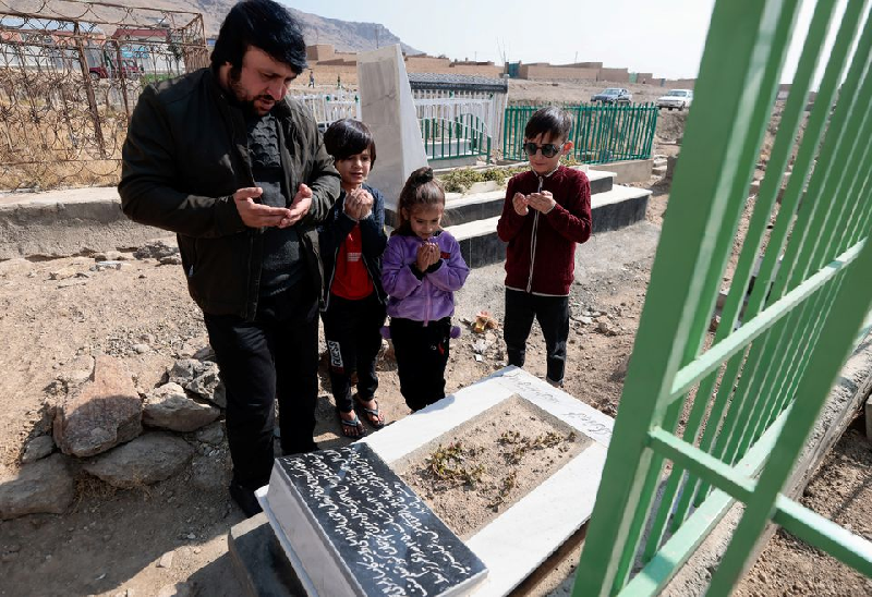 ajamal ahmadi stands with his nephews as they pray by the grave of arwin 7 a relative who was a victim of a us drone strike that killed 10 civilians including seven children in kabul afghanistan november 7 2021 photo reuters