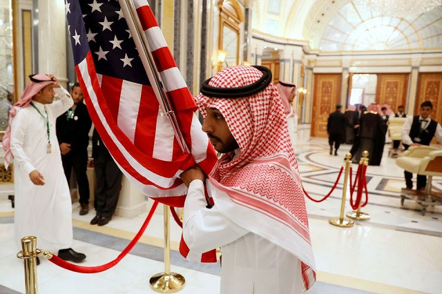 a worker carries a us flag into a meeting room ahead of us president donald trump s meeting with gulf cooperation council leaders in riyadh saudi arabia may 21 2017 photo reuters