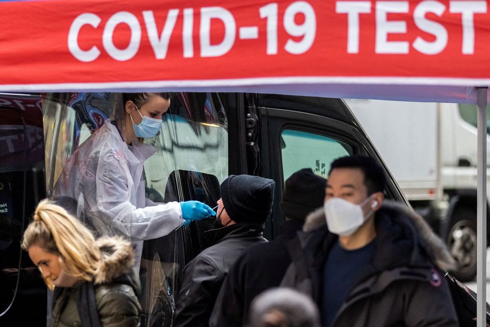 a man is tested for the coronavirus disease covid 19 at a mobile covid 19 testing unit as pedestrians make their way in the sidewalk during the spread of the omicron coronavirus variant in manhattan new york us december 8 2021 photo reuters