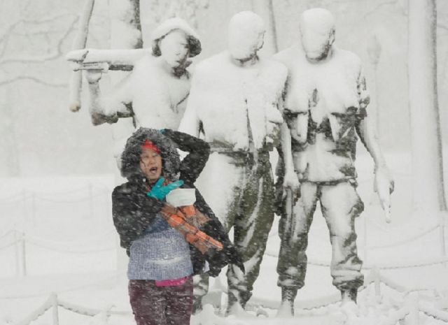 a woman poses for a photograph beneath a snow covered statue at the vietnam veterans memorial on the national mall in washington us january 3 2022 photo reuters a woman poses for a photograph beneath a snow covered statue at the vietnam veterans memorial on the national mall in washington us january 3 2022 photo reuters