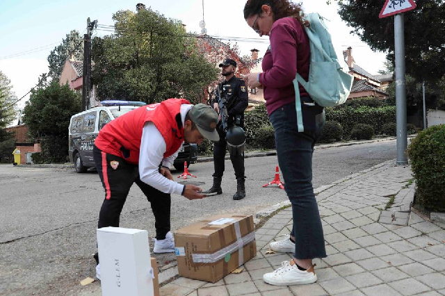 a courier attempts to deliver packages as police cordon off the perimeter outside the ukrainian embassy in madrid after a bloody package arrived at the embassy in the wake of several letter bombs arriving at targets connected to spanish support of ukraine amidst russia s invasion of ukraine in madrid spain december 2 2022 photo reuters