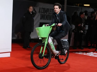 timoth e chalamet rides in lime bike to bob dylan biopic premiere