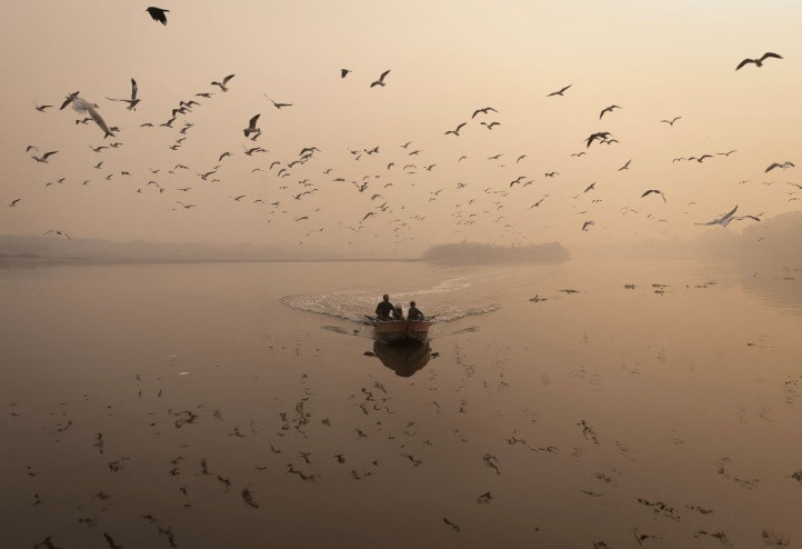 a man sails his boat amidst heavy smog in the yamuna river in the old quarters of delhi india november 4 2022 reuters adnan abidi