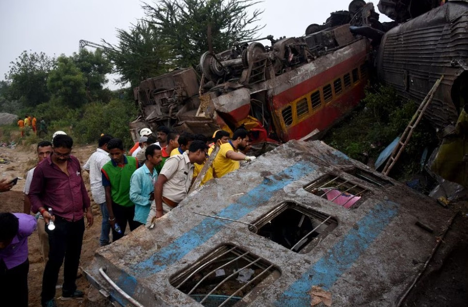 بھارت کی مشرقی ریاست اوڈیشہ کے ضلع بالاسور میں دو مسافر ٹرینوں کے ٹکرانے کے بعد بچ جانے والے افراد کی تلاش میں امدادی کارکن 3 جون 2023 فوٹو رائٹرز