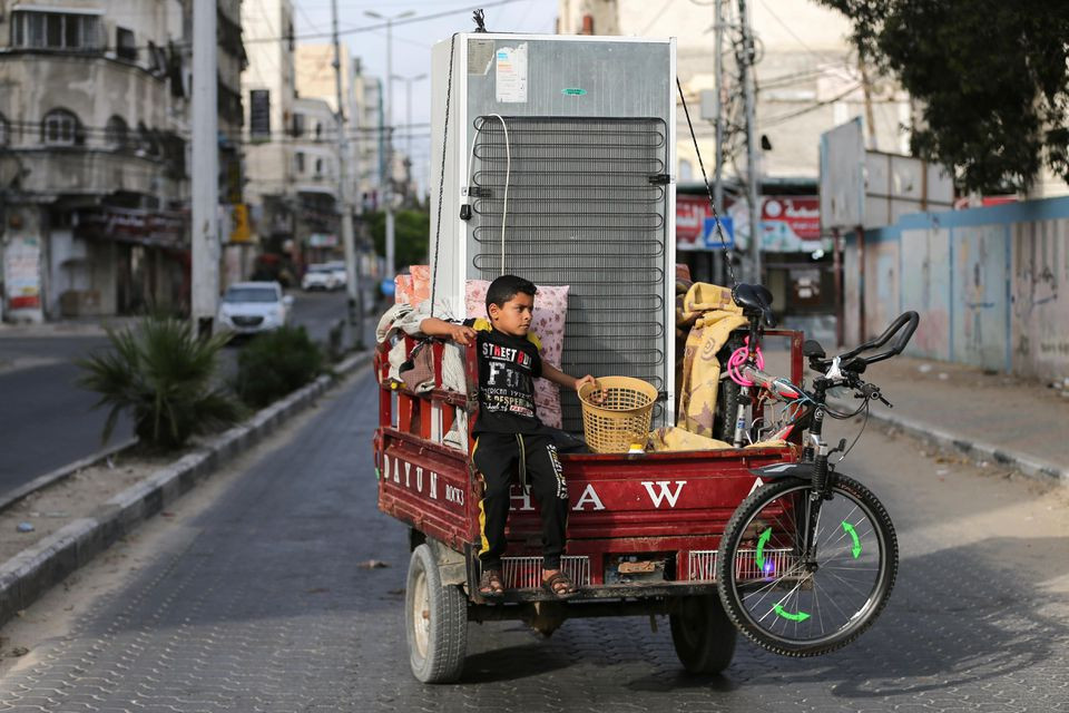 a palestinian boy riding on an auto rickshaw loaded with his family s belongings heads to their home as he leaves a united nations run school where they took refuge during the recent cross border violence between palestinian forces and israel following israel hamas truce in gaza may 21 2021 photo reuters