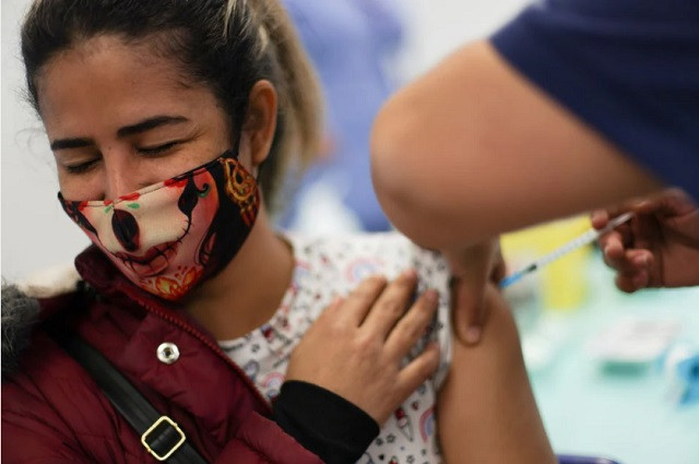 a woman receives a dose of pfizer biontech coronavirus disease covid 19 vaccine during a vaccination campaign inside the university of santiago chile june 30 2021 photo reuters