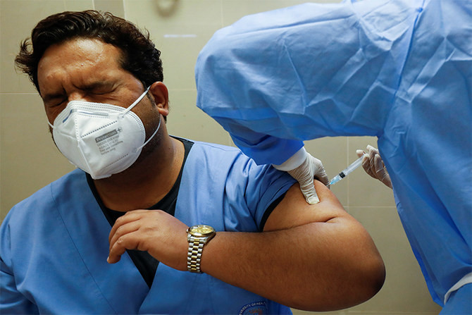 a health worker reacts while receiving a dose of the sinopharm coronavirus disease covid 19 vaccine donated by china at a vaccination centre in karachi february 3 2021 photo reuters file