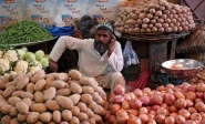 a man selling vegetables waits for customers at his makeshift stall at the empress market in karachi photo reuters