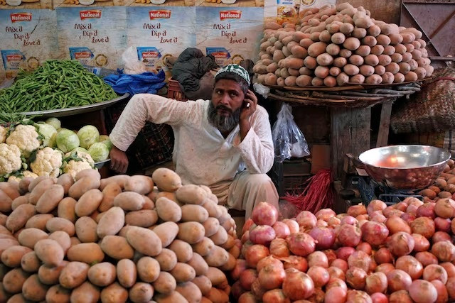 a man selling vegetables waits for customers at his makeshift stall at the empress market in karachi photo reuters