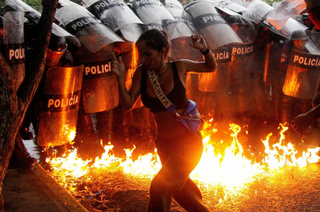 a demonstrator reacts when molotov cocktails hit the ground in front of security forces during protests against election results in puerto la cruz venezuela july 29 2024 photo reuters a demonstrator reacts when molotov cocktails hit the ground in front of security forces during protests against election results in puerto la cruz venezuela july 29 2024 photo reuters