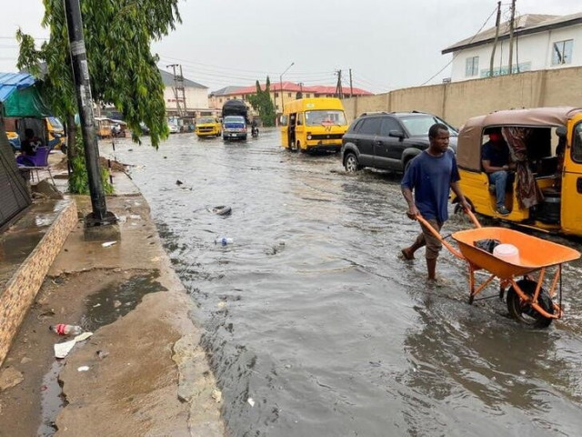 a man wades through flood water with his wheel barrow after rainfall with some objects seen floating in the flood water in lagos nigeria april 17 2021 reuters seun sanni a man wades through flood water with his wheel barrow after rainfall with some objects seen floating in the flood water in lagos nigeria april 17 2021 reuters seun sanni
