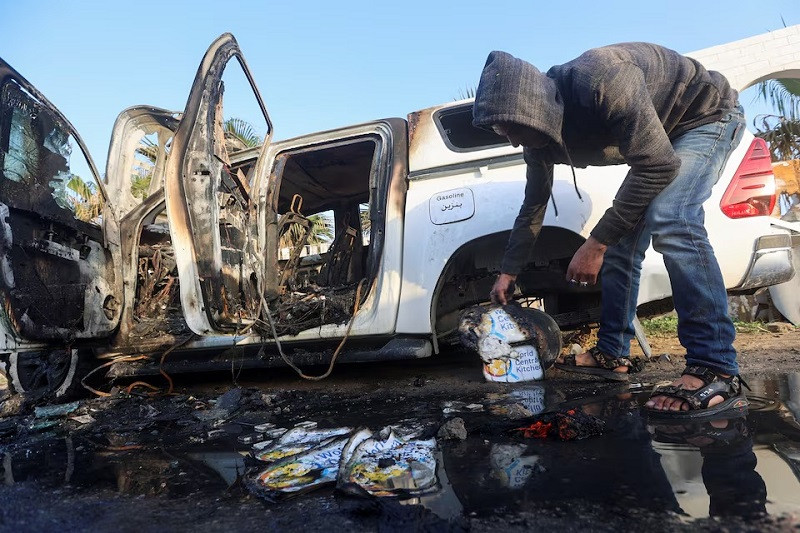 A Palestinian inspects near a vehicle where employees from the World Central Kitchen (WCK) were killed in an Israeli airstrike, in Deir Al-Balah, in Gaza, April 2. The strike on the WCK convoy killed citizens of Australia, Britain and Poland as well as Palestinians and a dual citizen of the United States and Canada. PHOTO: REUTERS