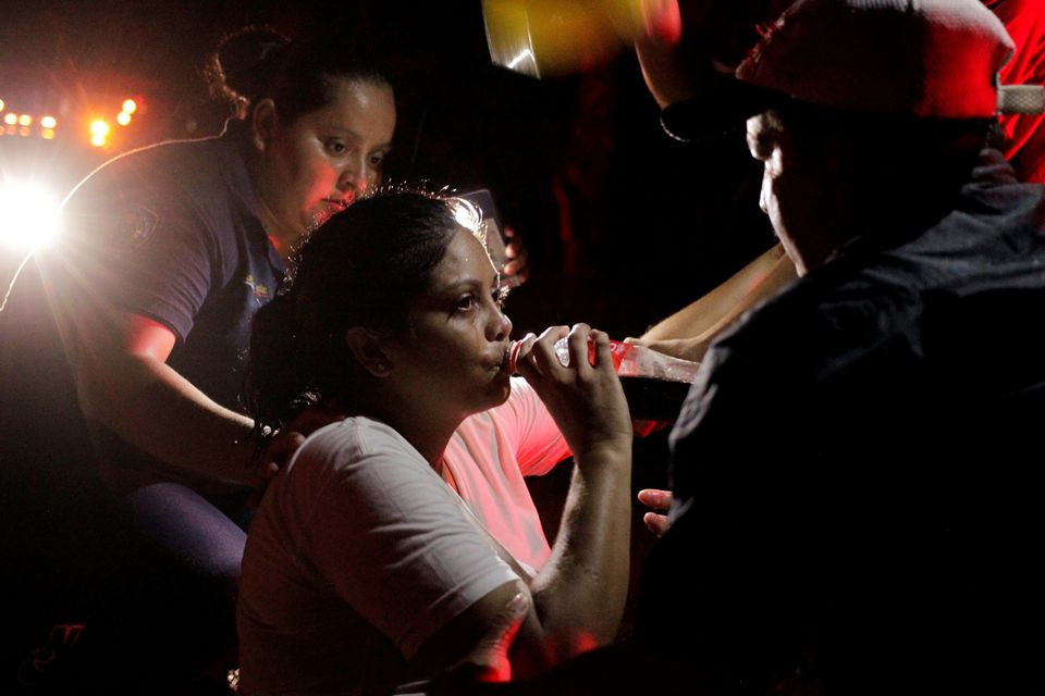 a migrant woman drinks a beverage while she is helped by police officers after she passed out as while taking part in a caravan heading to mexico city in el fortin mexico october 29 2021 photo reuters