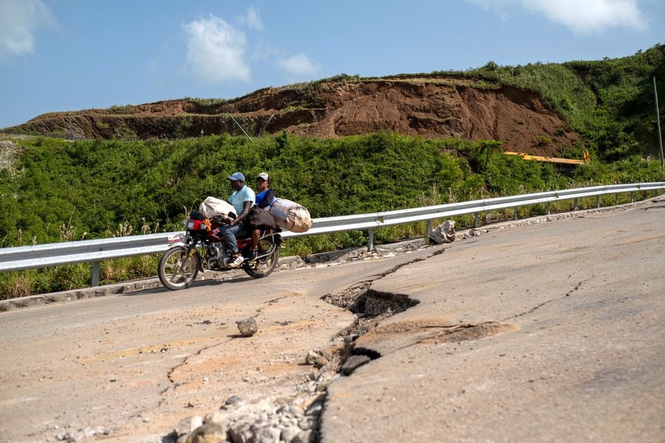 a motorcycle drives on a road with cracks caused by a 7 2 magnitude quake in marceline haiti august 22 2021 photo reuters