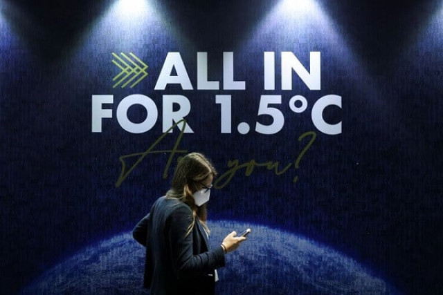 a delegate walks past a sign during the un climate change conference cop26 in glasgow scotland britain november 11 2021 photo reuters