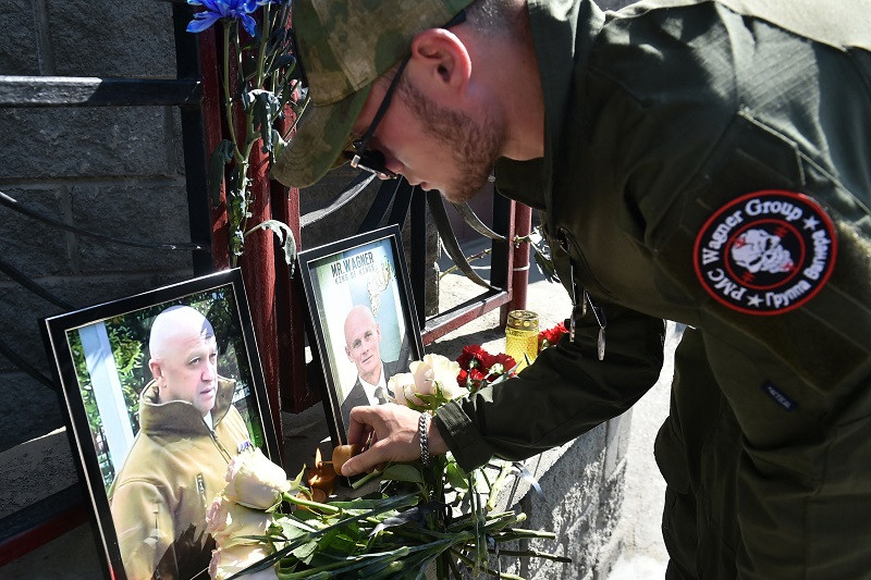 a member of private mercenary group wagner pays tribute to yevgeny prigozhin l and dmitry utkin photo afp