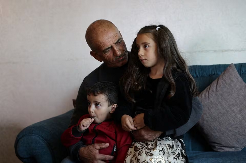 Ismael Wawi, father of a female Palestinian detainee Deema Al-Wawi sits with his children, near Hebron in the Israeli-occupied West Bank, November 15, 2023. PHOTO: REUTERS
