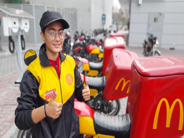 a female food delivery driver poses for a picture photo express