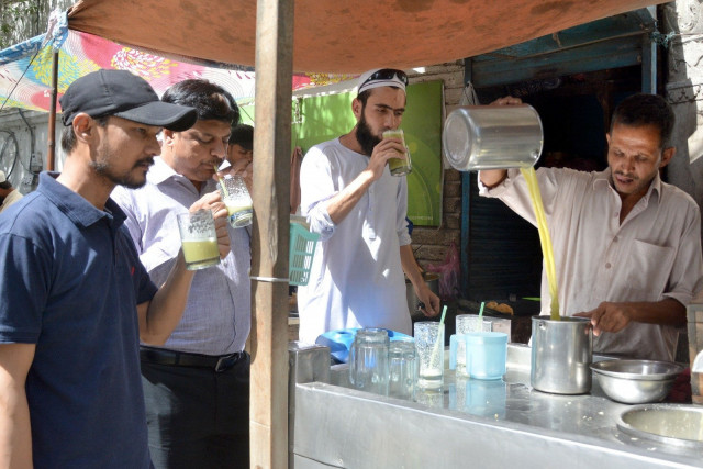 people drink chilled sugarcane juice along a street in karachi to avoid heat exhaustion on a hot summer day photo express people drink chilled sugarcane juice along a street in karachi to avoid heat exhaustion on a hot summer day photo express