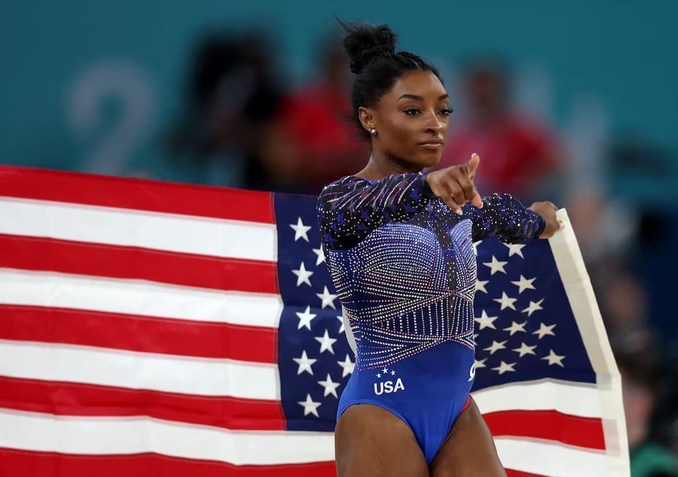 simone biles of united states celebrates with her national flag after winning gold photo reuters