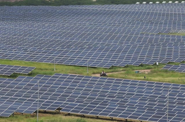 a man rides a motorcycle along the solar panels in gujarat solar park also called charanka solar park at patan district in gujarat india on september 12 2024 photo reuters