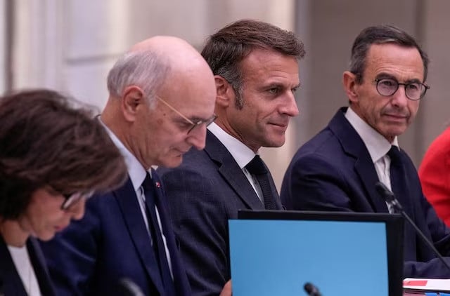 french president emmanuel macron is flanked by new justice minister didier migaud and new interior minister bruno retailleau during the first weekly cabinet meeting at the elysee palace on september 23 2024 in paris france photo reuters