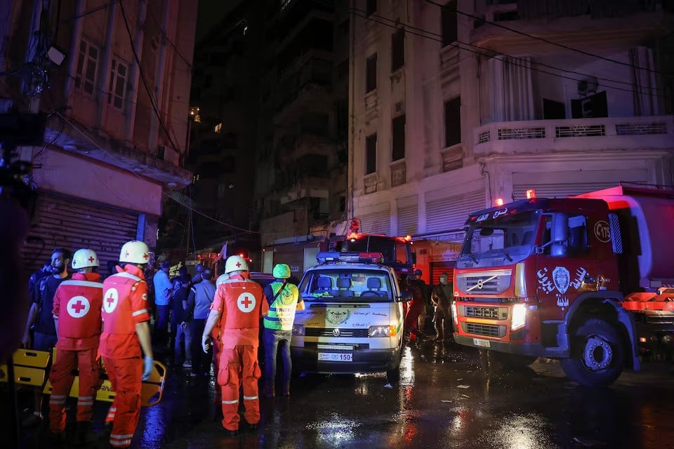 members of the red cross work at the site of an israeli air strike amid ongoing hostilities between hezbollah and israeli forces in ras al  nabaa in beirut lebanon on october 10 2024 photo reuters