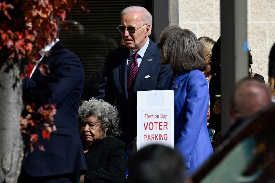 us president joe biden helps a woman in a wheelchair as he arrives to vote in the 2024 presidential election in new castle delaware us photo reuters