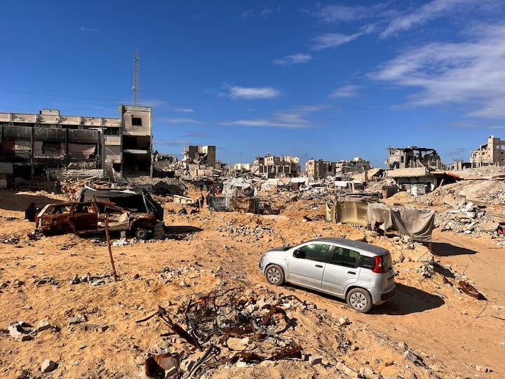 palestinians walk through a damaged site amid the israel hamas conflict in khan younis southern gaza on november 27 2024 photo reuters