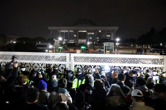 police officers stand guard at the gate of the national assembly after south korean president yoon suk yeol declared martial law in seoul south korea on december 4 2024 photo reuters police officers stand guard at the gate of the national assembly after south korean president yoon suk yeol declared martial law in seoul south korea on december 4 2024 photo reuters