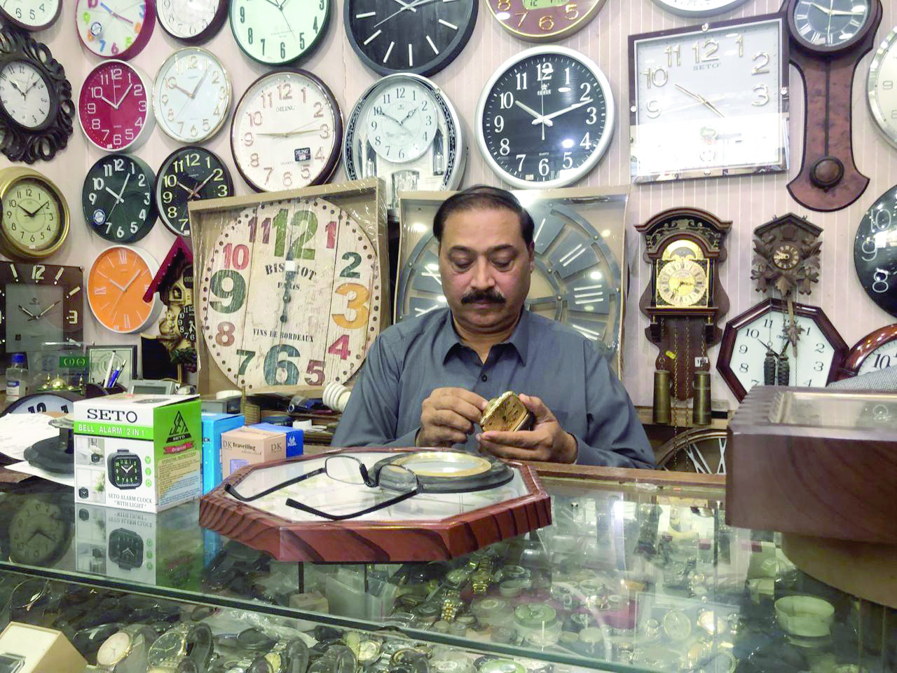 a watchmaker repairs a small table clock at his shop in the federal capital blowing the final breaths into a dying trade photo express