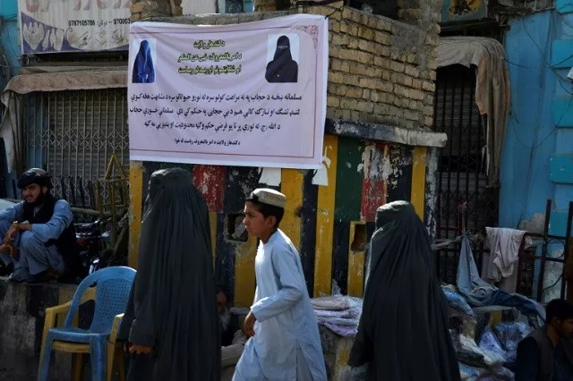 burqa clad women walk past a banner in kandahar telling them how to dress in public photo afp burqa clad women walk past a banner in kandahar telling them how to dress in public photo afp