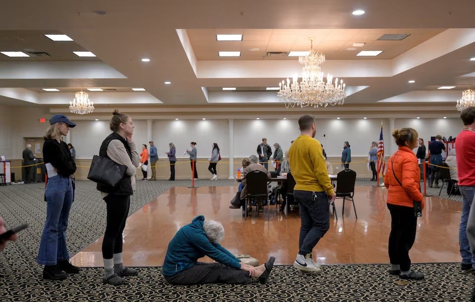 a woman sits and stretches as she waits to vote at the italian heritage centre in maine s 2nd congressional district in portland photo reuters