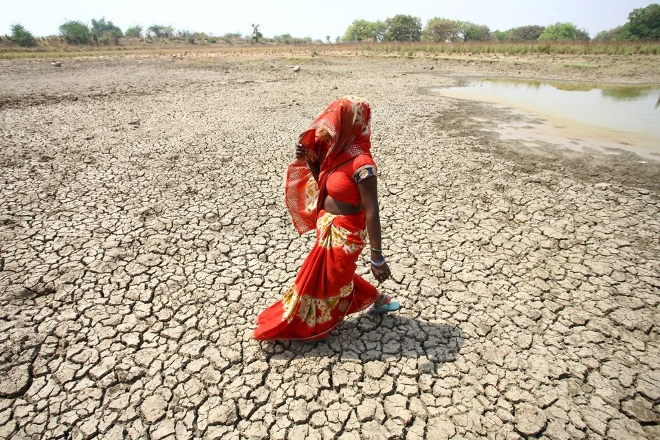 2 2 a woman walks on the bottom of a dried pond on a hot day in mauharia village in the northern state of uttar pradesh india may 4 2022 reuters ritesh shukla file photo