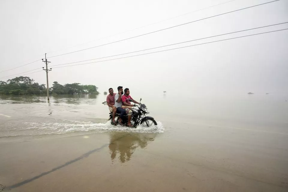 people ride on a bike on a submerged road during a widespread flood in the northeastern part of the country in sylhet bangladesh june 19 2022 reuters people ride on a bike on a submerged road during a widespread flood in the northeastern part of the country in sylhet bangladesh june 19 2022 reuters