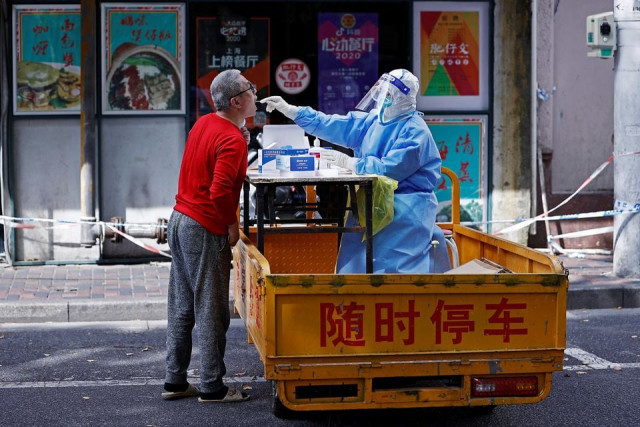 a medical worker in a protective suit collects a swab from a resident for nucleic acid testing amid the coronavirus disease covid 19 outbreak in shanghai china april 22 2022 photo reuters a medical worker in a protective suit collects a swab from a resident for nucleic acid testing amid the coronavirus disease covid 19 outbreak in shanghai china april 22 2022 photo reuters