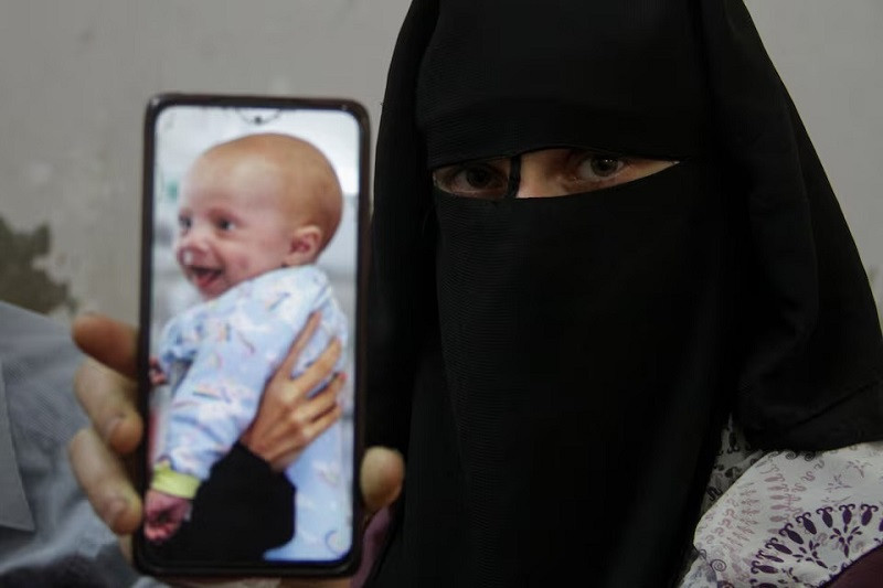 sondos mukat mother of yehia hamuda displays a picture of him in jabalia in the northern gaza strip april 25 2024 photo reuters