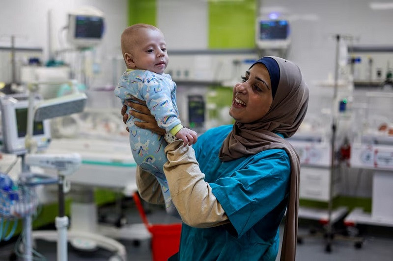 A nurse holds Yehia Hamuda, a Palestinian infant, who was evacuated to south Gaza as a premature baby after Israeli forces raided Kamal Adwan hospital in northern Gaza Strip and is currently separated from his parents due to an Israeli checkpoint that separates north Gaza from the south, at Al-Emirati hospital, in Rafah in the southern Gaza Strip, April 24, 2024. PHOTO: REUTERS