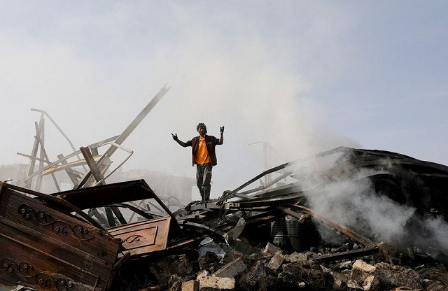 a worker reacts as he stands on the wreckage of a vehicle oil and tires store hit by saudi led air strikes in sanaa yemen july 2 2020 photo reuters