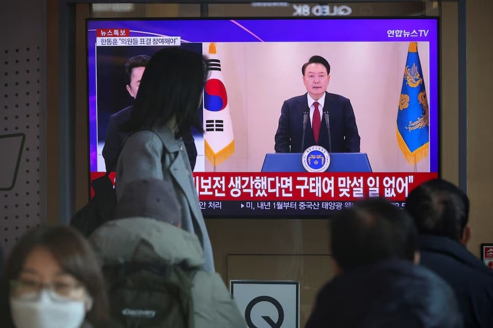 people watch a tv screen broadcasting south korean president yoon suk yeol delivering an address to the nation at a railway station in seoul south korea on december 12 2024 photo reuters