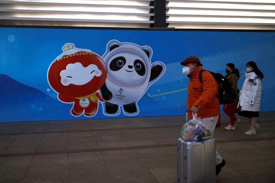 travellers walk past an image of the beijing 2022 winter olympics mascots at a railway station during the chinese lunar new year holiday in beijing china february 3 2022 photo reuters