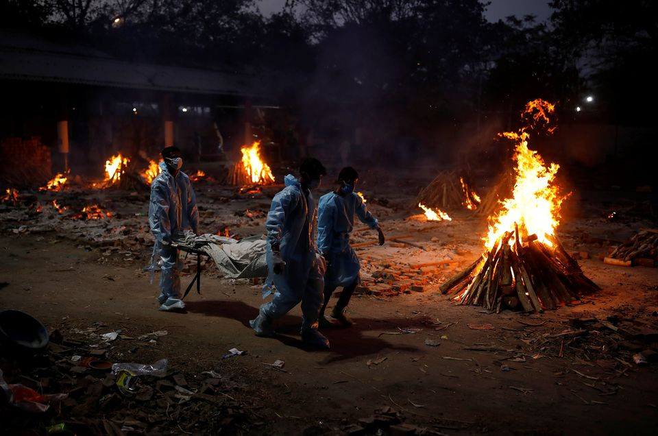 people carry a body of a man who died from the coronavirus disease covid 19 during his cremation at a crematorium in new delhi india may 3 2021 reuters