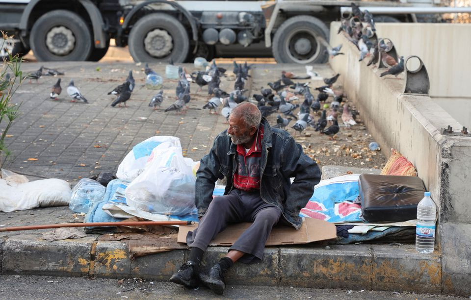 A homeless man sits on a curb along a street in Beirut, Lebanon November 17, 2022. REUTERS/Mohamed Azakir