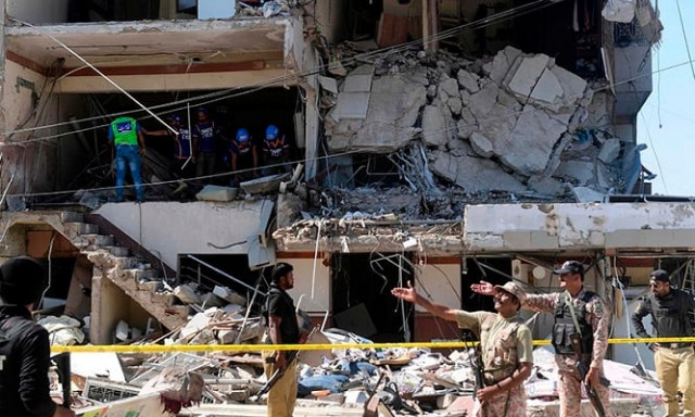 security and rescue officials stand amid the damaged structure photo afp