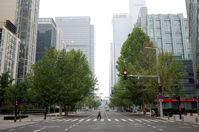 a woman wearing a face mask crosses a road at the central business district cbd amid the coronavirus disease covid 19 outbreak in beijing china may 10 2022 photo reuters