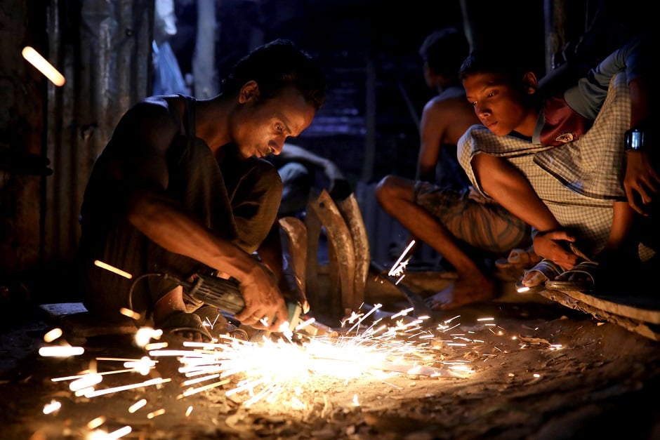 A Rohingya refugee blacksmith sharpens a knife ahead of Eidul Azha in Bangladesh on August 21, 2018. PHOTO:REUTERS