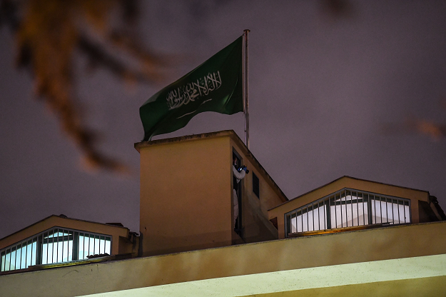 A Turkish forensic stands next to the Saudi flag, on the roof of the Saudi Arabia's consulate in Istanbul. PHOTO:  AFP