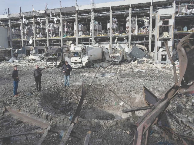 law enforcement officers inspect a crater next to the heavily damaged logistics hub of the novus supermarket following russian missiles and drones strikes in kyiv photo afp law enforcement officers inspect a crater next to the heavily damaged logistics hub of the novus supermarket following russian missiles and drones strikes in kyiv photo afp
